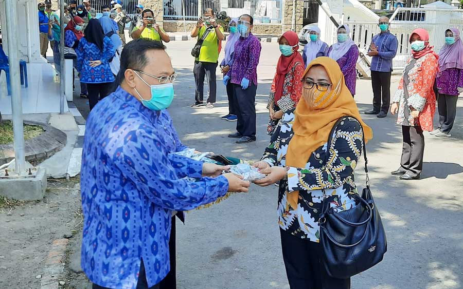 Kepala Dinas Kesehatan (Dinkes) Kota Kediri, dr. Fauzan Adima saat menyerahkan masker secara simbolis kepada tenaga kesehatan yang bertugas membagikan masker kepada masyarakat. foto: MUJI HARJITA/ BANGSAONLINE