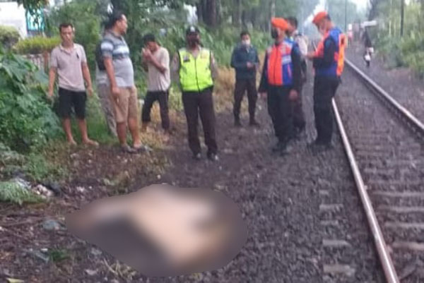 Petugas saat mengevakuasi korban tersambar kereta api di Gedangan, Sidoarjo.