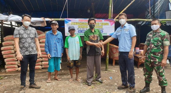 Direktur PT Berdikari Jaya Bersama (BJB) Kota Probolinggo, Yuwie Santoso menyerahkan bantuan semen kepada korban.
