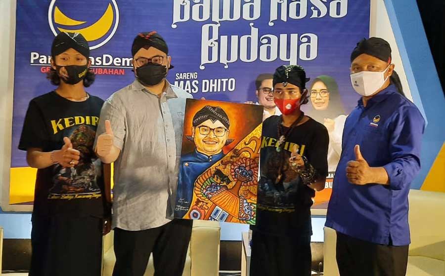 Calon Bupati Kediri Hanindhito Himawan Pramono (nomor 2 dari kiri) saat menerima cinderamata berupa lukisan dirinya dari dua pelukis didampingi oleh Ketua DPD Partai Nasdem Kabupaten Kediri, Lutfi Mahmudiono (paling kanan). foto: MUJI HARJITA/ BANGSAONLINE