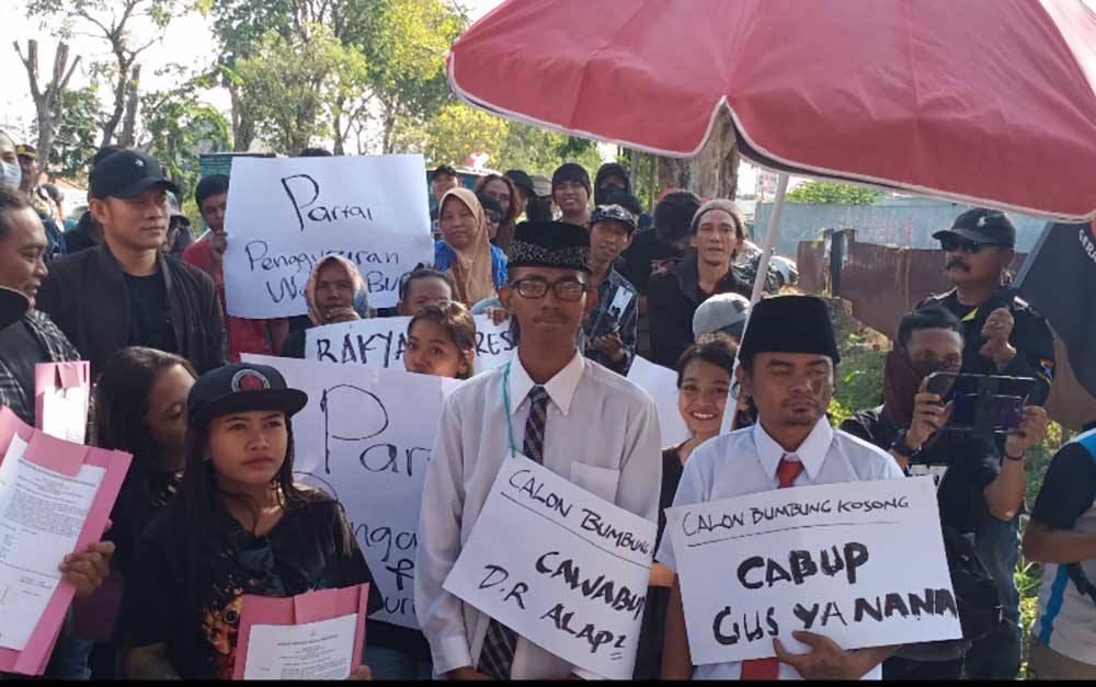 Mega Bagus Saputra (belakang, pakai kerpus) saat ikut demo mendukung bumbung kosong di KPU Gresik. Foto: SYUHUD/ BANGSAONLINE