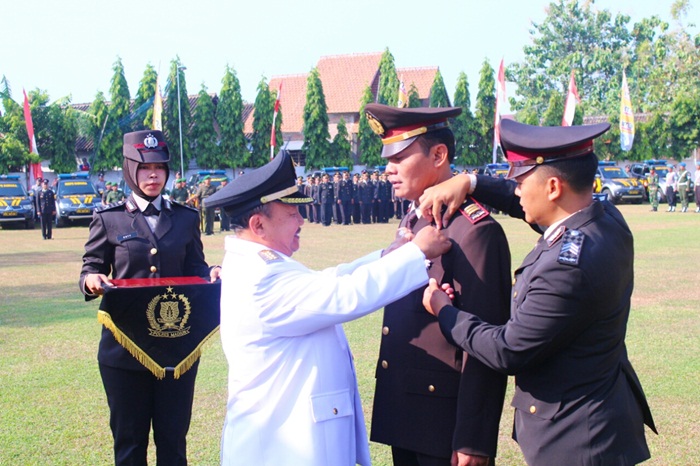 Bupati saat menyematkan penghargaan.