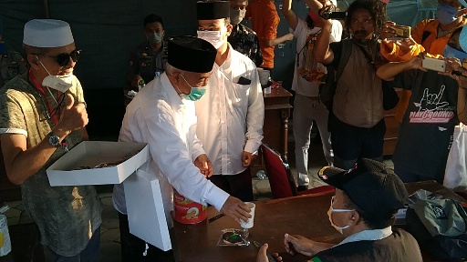 Prof Dr KH Asep Saifuddin Chalim, M.Ag, didampingi Habib Hasan Mulachela menyuguhkan kopi kepada para petugas posko covid-19 di Solo Jawa Tengah, Ahad (19/4/2020). foto: MA/ BANGSAONLINE.COM