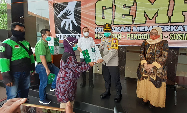 Penyerahan bantuan secara simbolis oleh Kapolres Mojokerto Kota didampingi pengurus Gempita kepada salah satu warga.