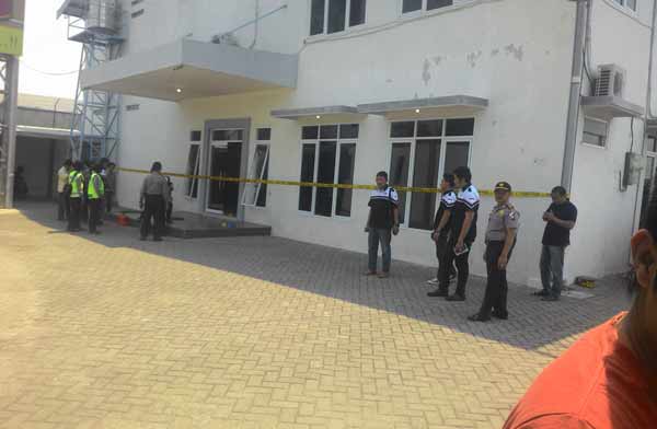 DIJAGA: Petugas kepolisian saat melakukan olah TKP di lokasi perampokan gudang cat Altex. foto: dendi martoni/BANGSAONLINE