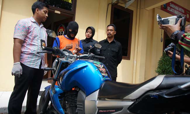 Tersangka saat diamnkan di Mapolres Jombang beserta motor yang digunakannya untuk beraksi. foto: rony suhartomo/ BANGSAONLINE