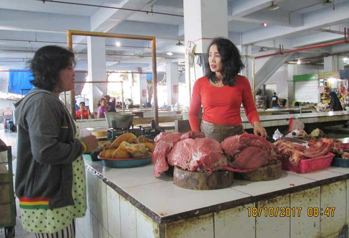 Pedagang daging PBM tengah melayani pembeli.