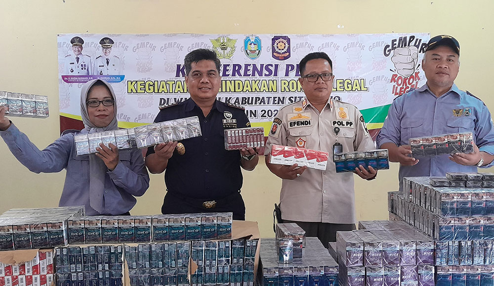 Pejabat Bea Cukai Jember dan Satpol PP Situbondo menunjukkan BB rokok ilegal hasil penindakan. Foto: BANGSAONLINE