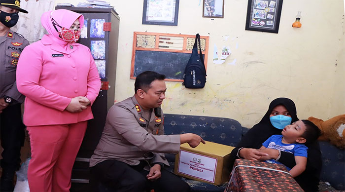 Kapolres Kediri, AKBP Agung Setyo Nugroho, didampingi istrinya saat menyerahkan bantuan kepada Andira Kayana Aldari.