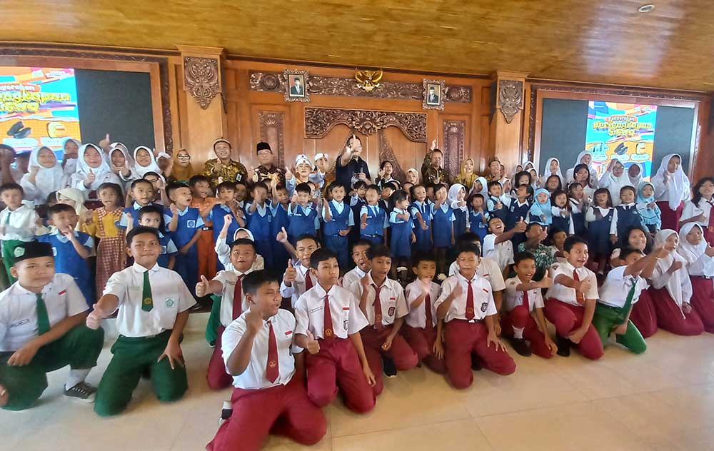 Pj Wali Kota Mojokerto Ali Kuncoro didampingi Plt Kepala Dikbud Ruby Hartoyo foto bersama para pelajar.
