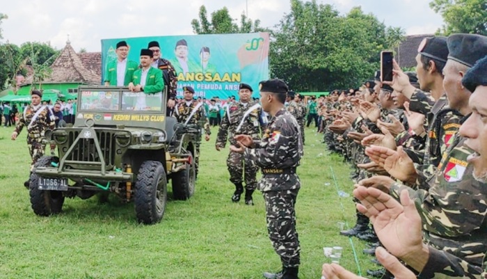 Ketua PC GP Ansor Kabupaten Kediri, Agus Rizmi Haitami Azizi, saat mengecek pasukan dengan naik Jeep jadul. foto: ist.