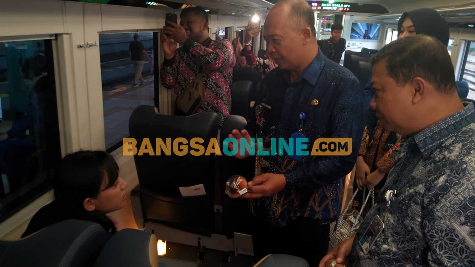 Kadisbudpar Magetan, Joko Trihono  saat bagikan kue khas Magetan kepada penumpang KA. Foto: Hendro Suhartono/BANGSAONLINE