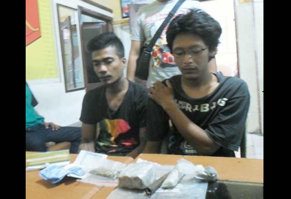 Dua tersangka beserta barang bukti saat diamankan di Mapolsek Waru. (foto: catur 