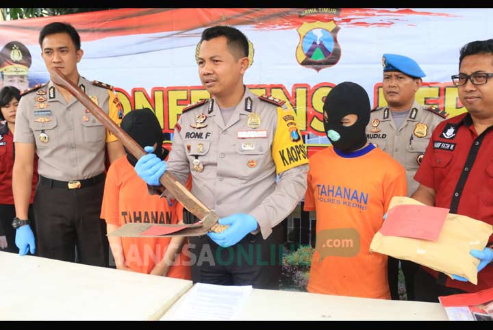 Kapolres Kediri AKBP Roni Faisal memegang cangkul yang digunakan mengubur bayi didampingi Wakapolres dan Kasatreskrim saat menggelar rilis sepasang kekasih yang tega bunuh bayinya sendiri. foto: ARIF K/ BANGSAONLINE