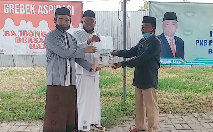 R. Imron Amin (kiri) bersama Syafiuddin menyerahkan sembako bersama secara simbolis kepada masyarakat terdampak Covid-19. foto: FAUZI/ BANGSAONLINE