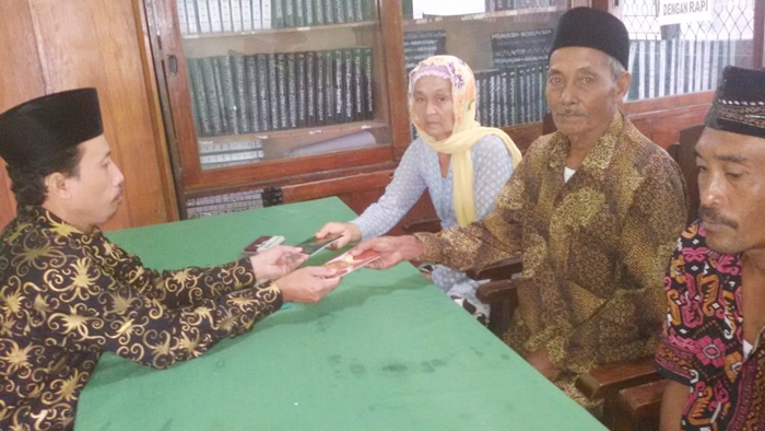 PASANGAN BAHAGIA: Mbah Muri dan Mbah Lasi saat menerima buku nikah dari penghulu.