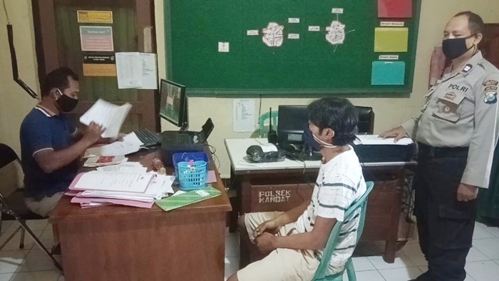 Tersangka Rudi P (baju putih) saat menjalani pemeriksaan di Mapolsek Kandat.