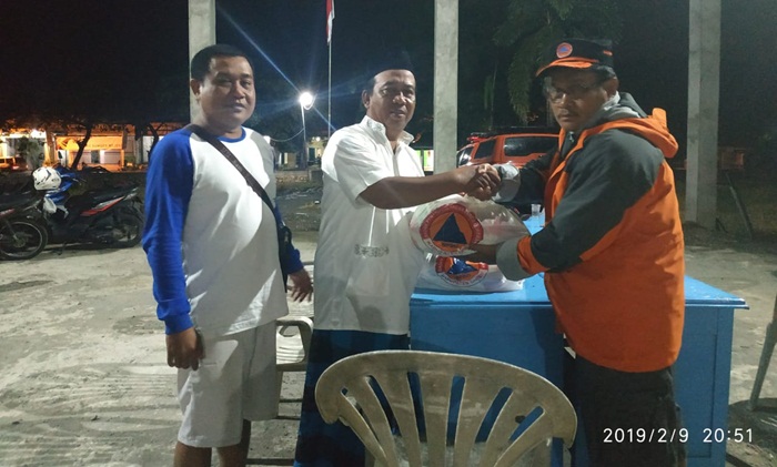 Kepala BPBD Gresik Tarso Sagito menyerahkan bantuan korban banjir di Desa Morowudi, Cerme. foto: SYUHUD A/ BANGSAONLINE