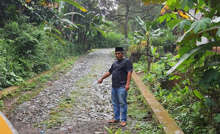 Warga menunjukkan kondisi jalan penghubung di Desa Ngantungan yang masih berupa makadam.