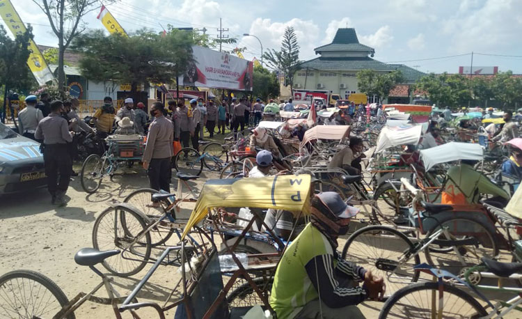 Para tukang becak saat menunggu giliran pembagian sembako dari kapolres.