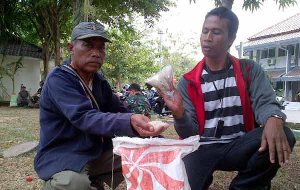 Warga menunjukkan raskin yang tak layak konsumsi dari Bulog Sampang. foto: bahri/BANGSAONLINE