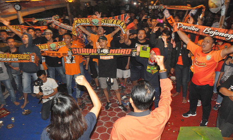 Abdullah Umar (kanan) mengepalkan tangan bersama Sally Atyasasmi (kiri) di hadapan ratusan suporter Persibo. (Foto: EKY NURHADI/BANGSAONLINE)