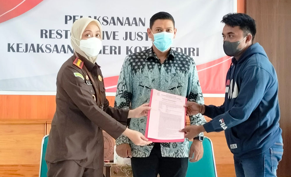 Kepala Kejari Kota Kediri Novika Muzairah Rauf menyerahkan surat ketetapan penghentian penuntutan (SKP2) kepada tersangka Mukamad Effendik disaksikan Wali Kota Abdullah Abu Bakar (tengah). Foto: Ist.