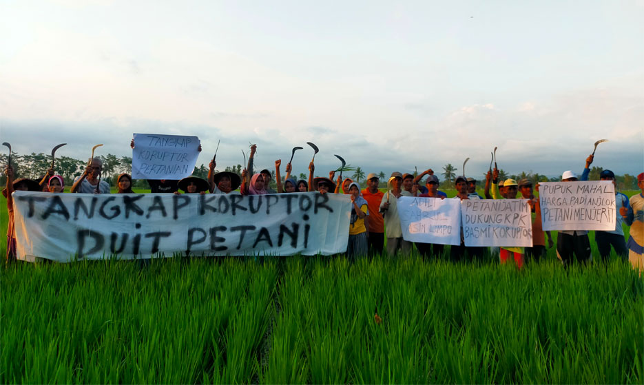 Puluhan petani di Lumajang, membentangkan spanduk desak KPK usut dugaan korupsi di Kementan. 