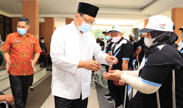 Gus Ipul meneteskan hand sanitizer kepada atlet paralympic kontingen Kota Pasuruan yang hendak berangkat.