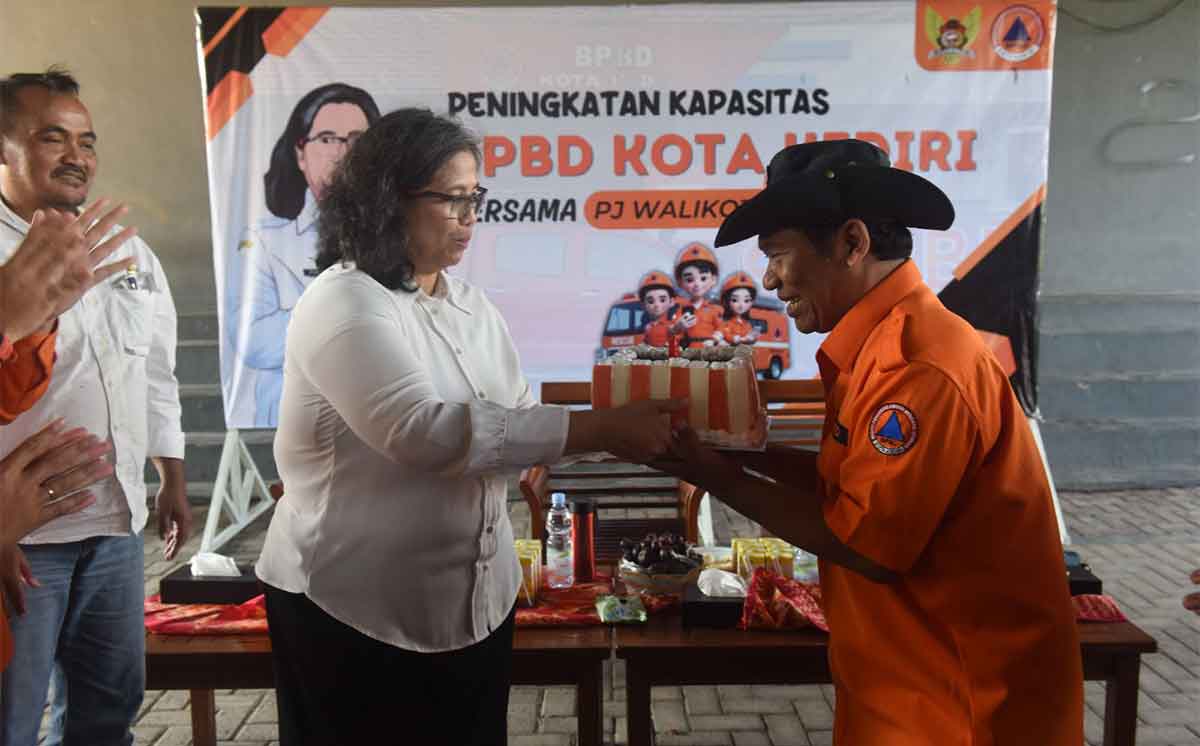 Pj Wali Kota Kediri, Zanariah, saat menyerahkan cendera mata dan juga kambing kepada salah satu pegawai BPBD yang purnatugas, Mohammad Aspan. Foto: Ist