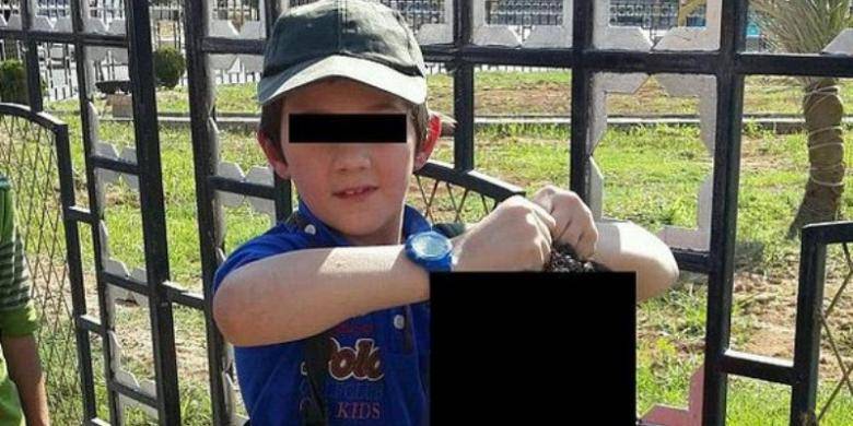 Foto yang diduga diambil di kota Raqqa, Suriah inilah yang disebar lewat akun Twitter milik Khaled Sharrouf, warga Australia yang bergabung dengan ISIS. Anak laki-laki yang memegang kepala terpenggal ini diduga kuat adalah putra Khaled. 