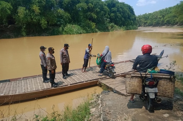 Anggota Polsek Pangkur sedang melakukan pemantauan kepada salah satu pelaku jasa penyeberangan.