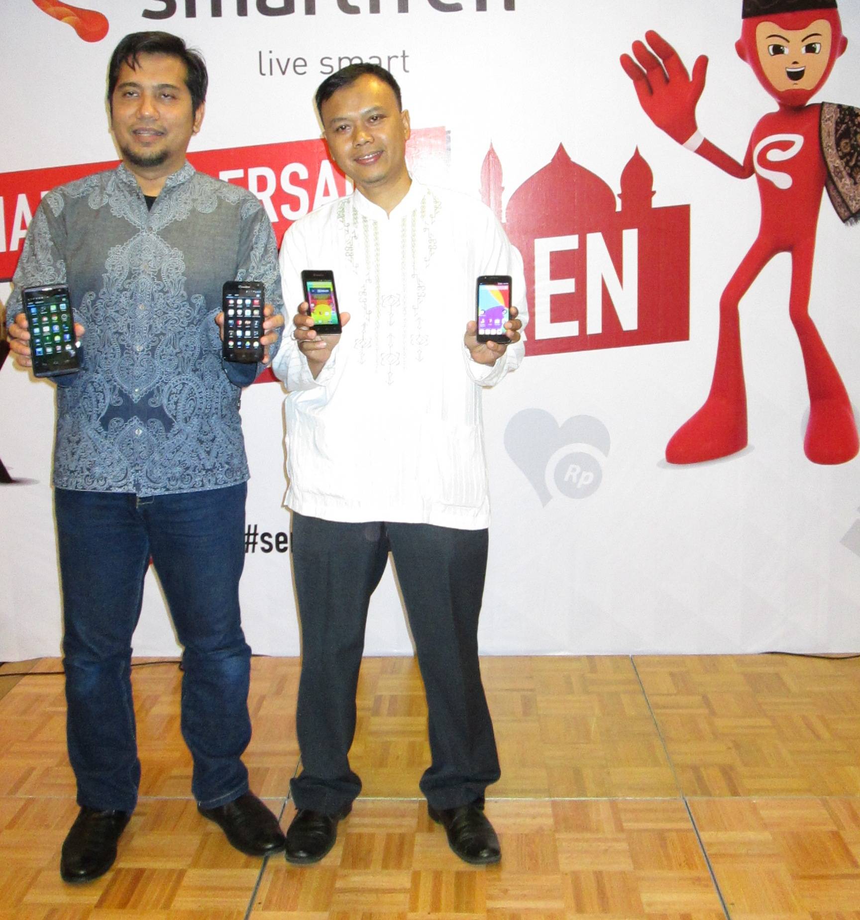 Muhammad Cahyadi (kiri) menunjukkan smartphone milik PT Smartfren Telecom Tbk. foto : nisa/bangsaonline