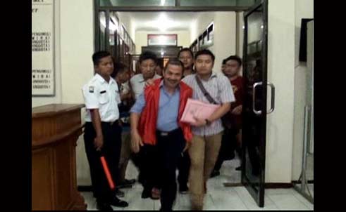 Masduqi Sekdakab Nganjuk berlari memasuki mobil tahanan dan dikawal ketat anggota polisi.