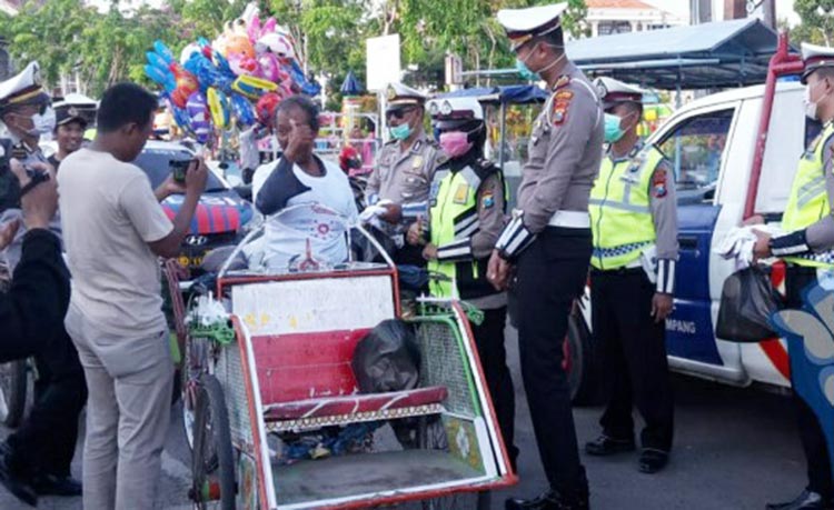 Kasatlantas Polres Sampang AKP Ayip Rizal saat mebagikan sembako kepada tukang becak.