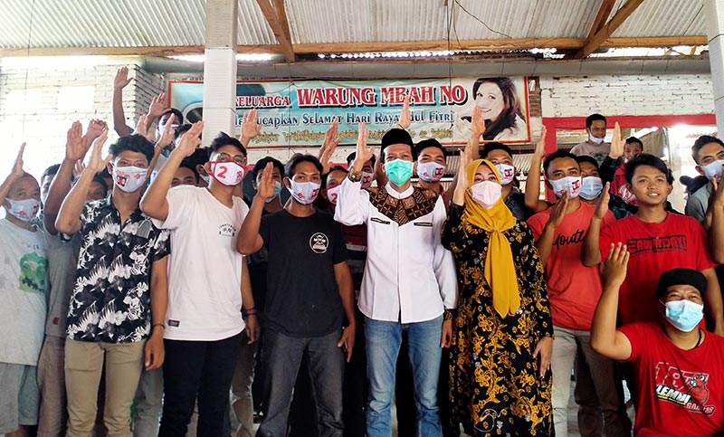 Syah dan istri (tengah) diapit anak muda Desa Kamulan, Kecamatan Durenan, Trenggalek, Sabtu (14/11/2020). foto: herman/ bangsaonline.com