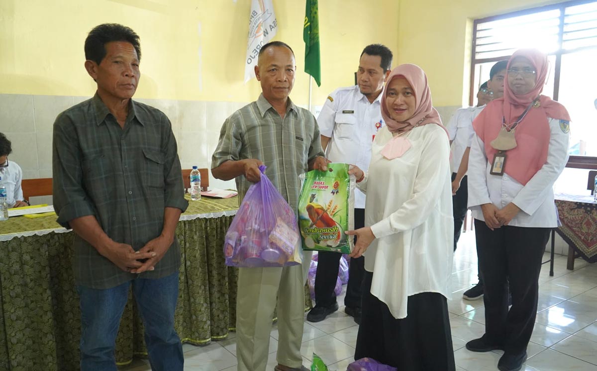 Plt Kepala Dinsos Kabupaten Kediri Dyah Saktiana saat menyerahkan secara simbolis bantuan kepada warga Desa Wonorejo. Foto: Ist.