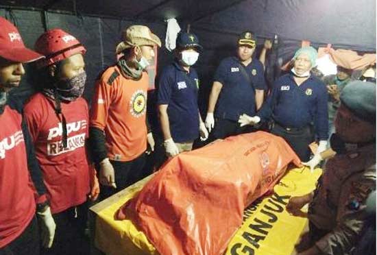 Petugas saat mengevakuasi korban ke tempat identifikasi. Tempat tersebut dipindah lantaran rawan longsor susulan.