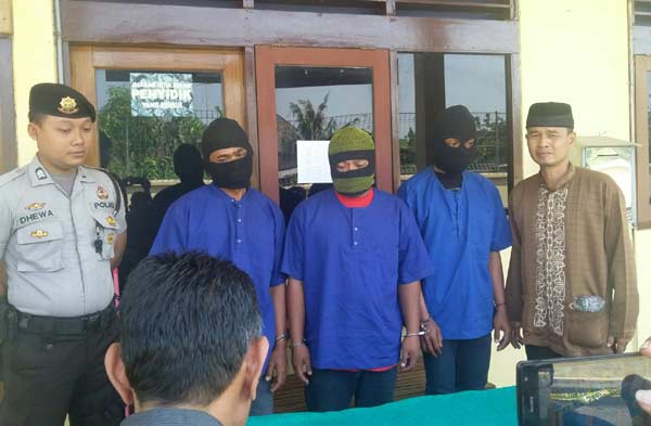 TERSANGKA: Tiga tersangka (baju biru) didampingi Kasubag Humas Polres Bojonegoro, AKP Nugroho Basuki (berpeci) dan seorang petugas lain di Mapolres setempat. Foto: Eky Nurhadi/BANGSAONLINE
