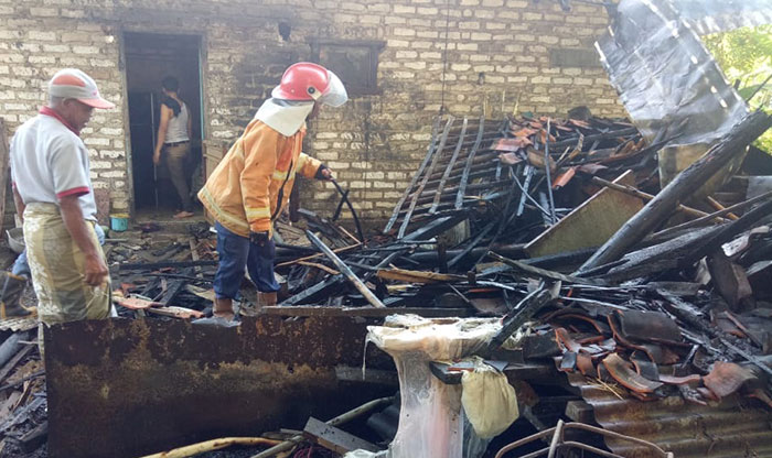 Petugas saat mengevakuasi kandang sapi dan dapur rumah yang terbakar di Pamekasan.