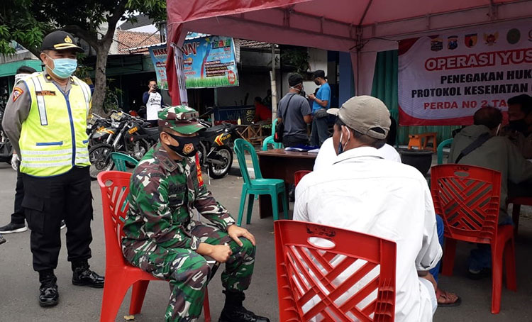 Dandim 0809/Kediri, Letkol Kav. Dwi Agung Sutrisno, S.E., M.Si., (Han) saat berdialog dengan salah satu warga yang terjaring operasi yustisi di Jalan Bandar Ngalim. (foto: ist).