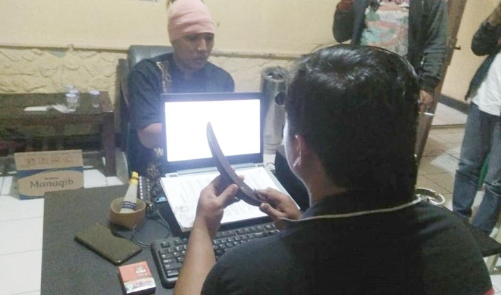 Petugas Polsek Mayangan memeriksa korban pembacokan. Tampak sebilah celurit yang diduga digunakan pelaku untuk membacok korban.