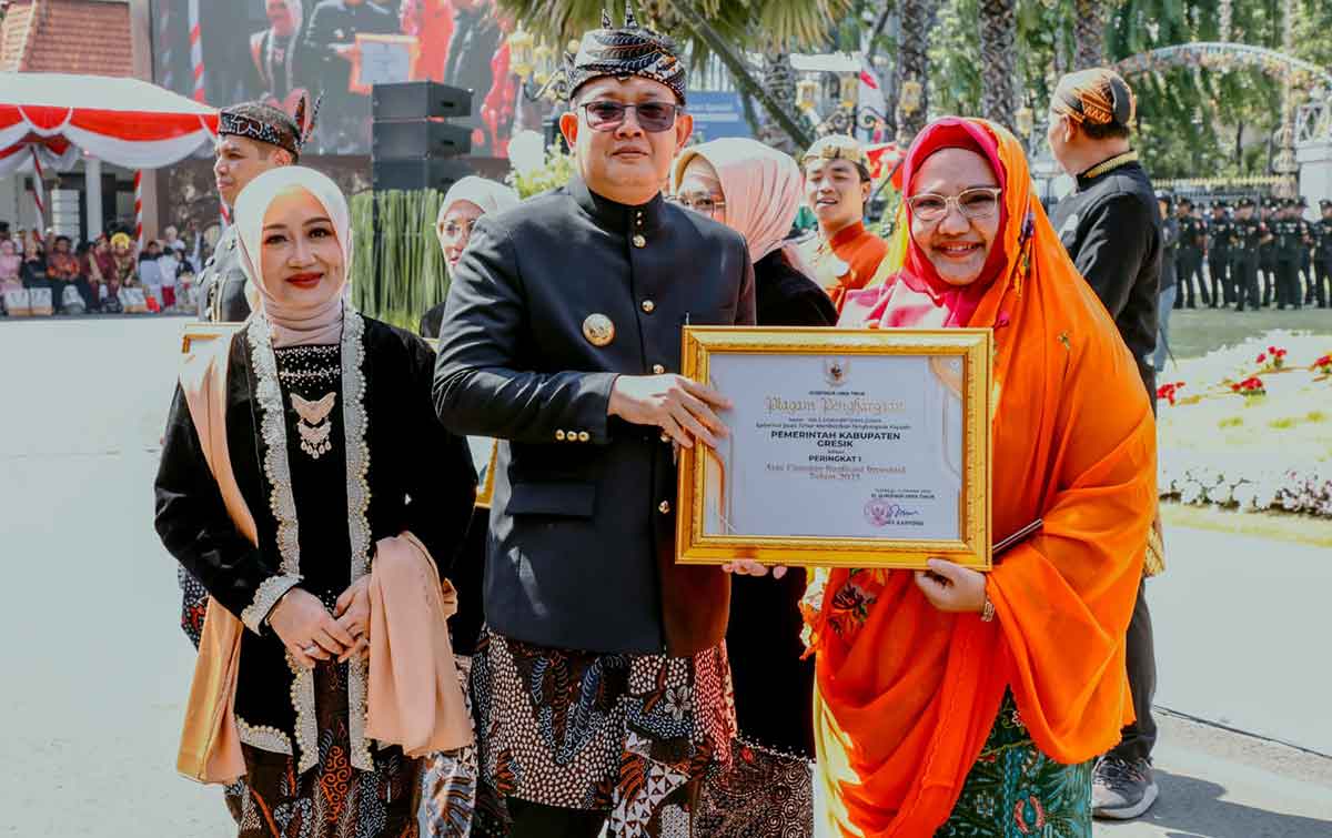 Pj Gubernur Jatim, Adhy Karyono (kiri), saat memberikan penghargaan kepada Plt Bupati Gresik, Aminatun Habibah, dalam upacara peringatan Hari Jadi ke-79 Provinsi Jawa Timur. Foto: Ist