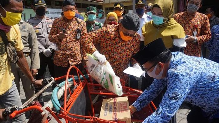 Bupati Sumenep Dr. KH. A. Busyro Karim saat memimpin pembagian sembako kepada ratusan Tukang Becak di Kecamatan Kalianget, Selasa (14/04/2020).