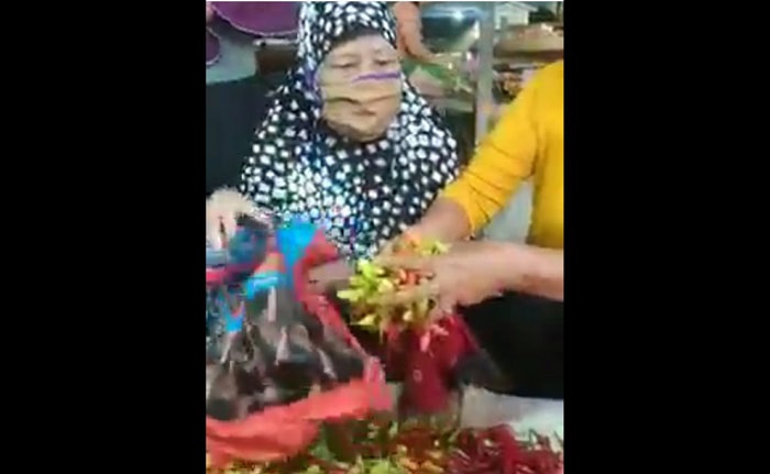 Seorang ibu tertangkap basah mengambil sejumlah cabai di Pasar Sumberayu Banyuwangi.