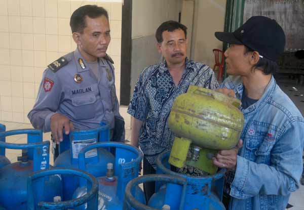 OPLOS. Tersangka mempraktekkan cara mengoplos elpiji di hadapan penyidik, kemarin. foto : int
