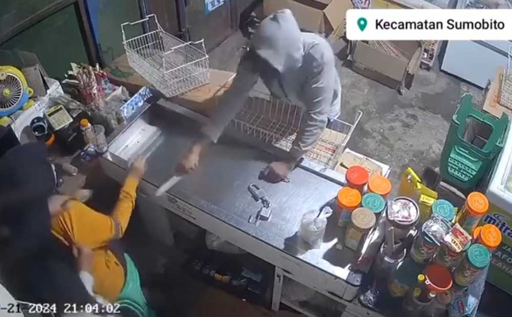 Tangkapan layar video rekaman CCTV saat pelaku mengancam karyawan menggunakan pisau.