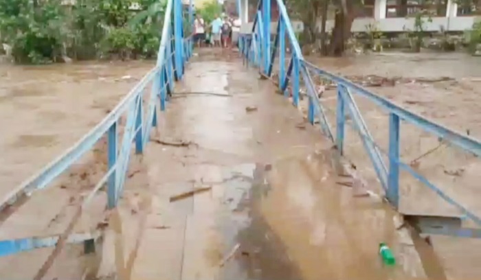 Banjir merendam salah satu jembatan penghubung desa hingga tak terlihat. 