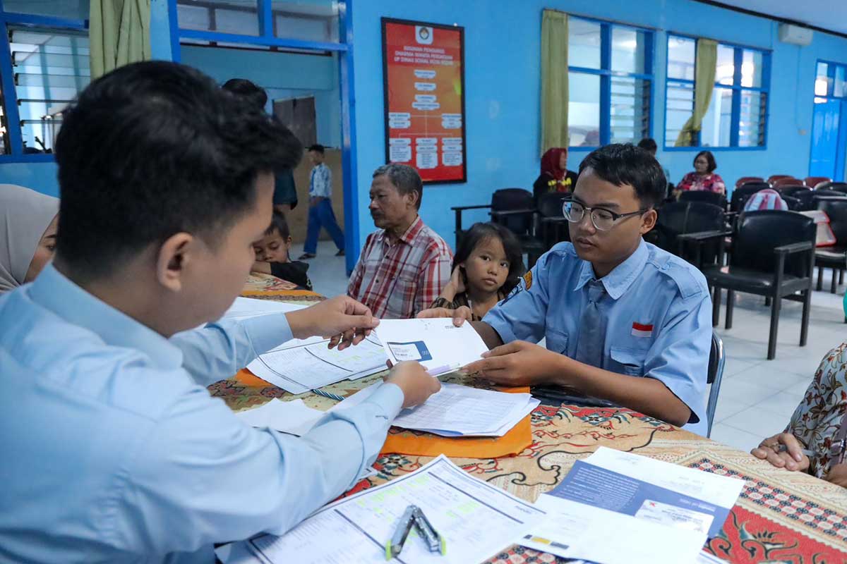 Petugas saat melayani penerima bantuan untuk melakukan aktivasi dan diberikan buku tabungan di Aula Dinas Sosial Kota Kediri, Kamis (6/6/2024).