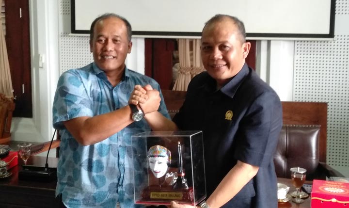 Ketua PWI Malang Raya Ariful Huda menerima cinderamata dari Ketua DPRD Kota Malang I Made Riandiana Kartika, Senin (17/02). foto: IWAN IRAWAN/ BANGSAONLINE